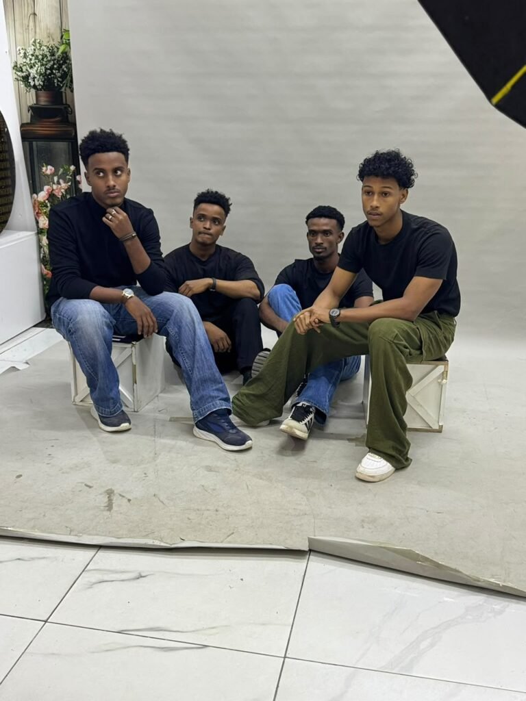 Young men in black T-shirts sitting together in a group discussion